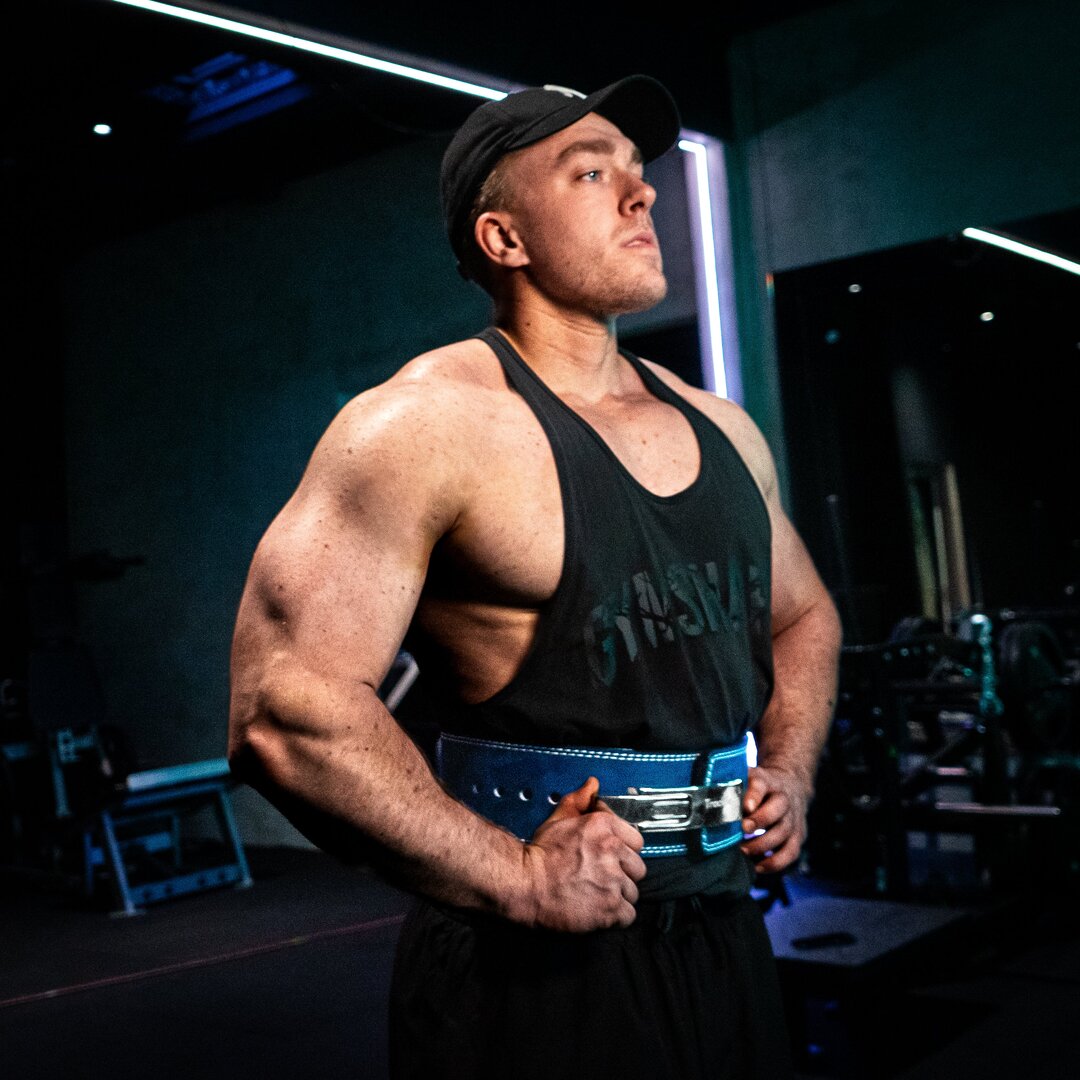 Mand med navy blåt Trackfie træningsbælte står nede i fitnesscenter