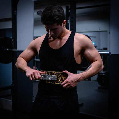 En mand spænder et gult træningsbælte i et fitnesscenter