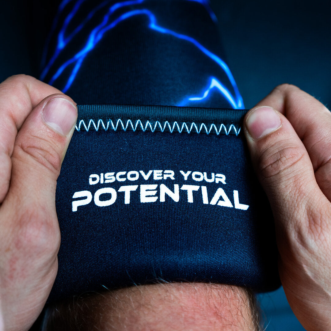 Blå Unlisted Strength knee sleeves bliver påført ben med teksten 'discover your potential' på indersiden