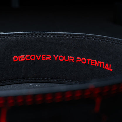 Indersiden af et rødt Unlisted Strength lever belt med teksten 'discover your potential'
