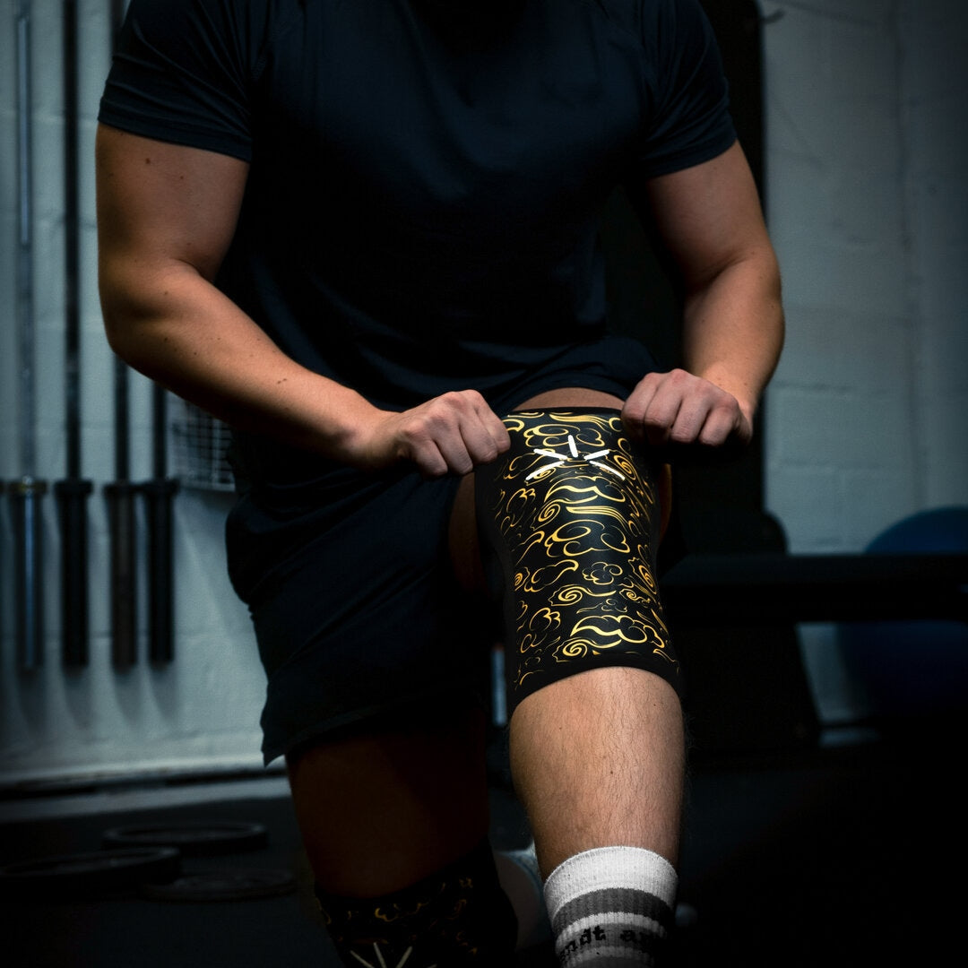 Mand trækker sine knee sleeves op til sit knæ