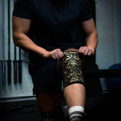 Mand trækker sine knee sleeves op til sit knæ