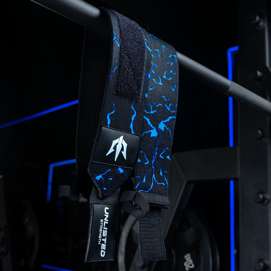 Blå Unlisted Strength wrist wraps der hænger ned fra barbell
