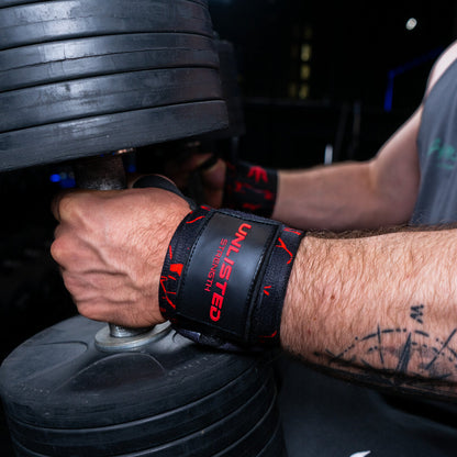 Nærbillede af røde wrist wraps på en mand der sidder med dumbbells